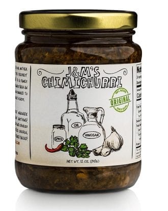 This is a jar of J&M's Chimichurri, labeled as "Original." The product boasts a traditional and natural look with hand-drawn illustrations of the ingredients, such as oil, vinegar, spice, and garlic. The packaging specifies that the net weight is 12 oz (340g). The overall design emphasizes authenticity, suggesting that this is a traditional and genuine chimichurri sauce. The green "Original" badge further accentuates the authenticity of the product. The rich, vibrant contents of the jar seem to be packed with herbs and spices, promising a flavorful experience.