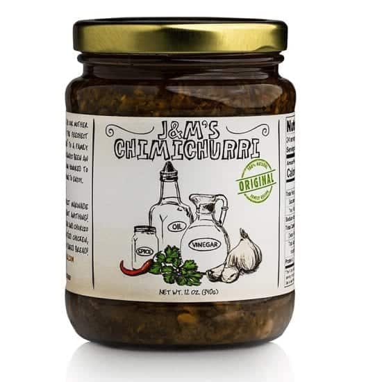 This is a jar of J&M's Chimichurri, labeled as "Original." The product boasts a traditional and natural look with hand-drawn illustrations of the ingredients, such as oil, vinegar, spice, and garlic. The packaging specifies that the net weight is 12 oz (340g). The overall design emphasizes authenticity, suggesting that this is a traditional and genuine chimichurri sauce. The green "Original" badge further accentuates the authenticity of the product. The rich, vibrant contents of the jar seem to be packed with herbs and spices, promising a flavorful experience.