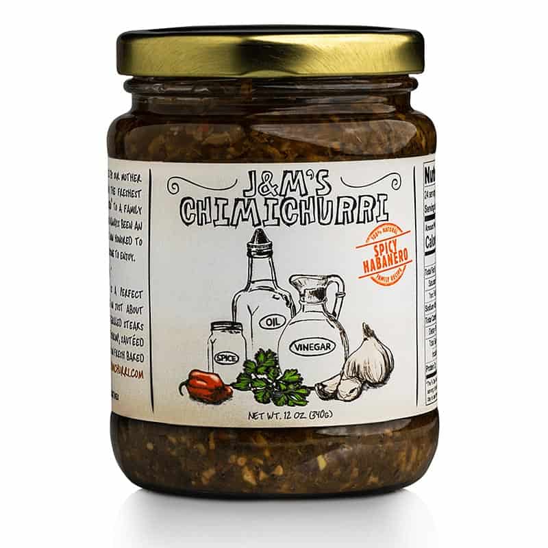 This jar features J&M's Chimichurri labeled with a "Spicy Habanero" badge. The design showcases a handcrafted appeal, highlighted by hand-drawn illustrations of the main ingredients like oil, vinegar, spice, garlic, and notably, a habanero pepper, indicating the spicy character of this variant. The badge, in bright red with the label "Spicy Habanero," signals that this edition of chimichurri sauce promises an intense heat, ideal for those who appreciate a fiery kick in their dishes. The product has a net weight of 12 oz (340g). Like the other versions, the design underscores an authentic and traditional feel, suggesting that the sauce is crafted with care. The inclusion of the habanero pepper illustration hints at an elevated level of spiciness for those seeking a bolder flavor experience.